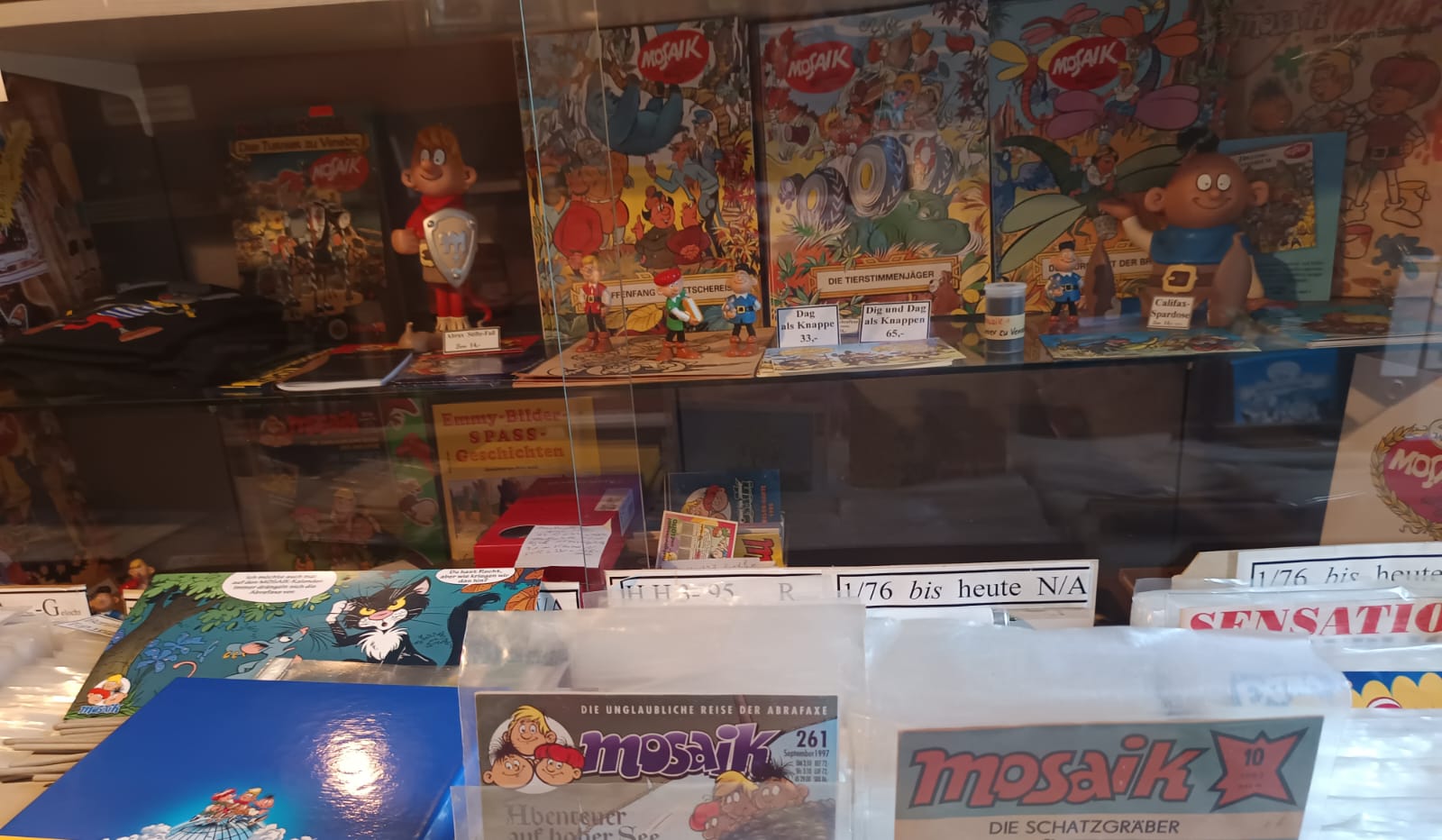 Vitrine mit Mosaik Heften, Digedags Figuren und Sammlerstücken im Modellbahnland